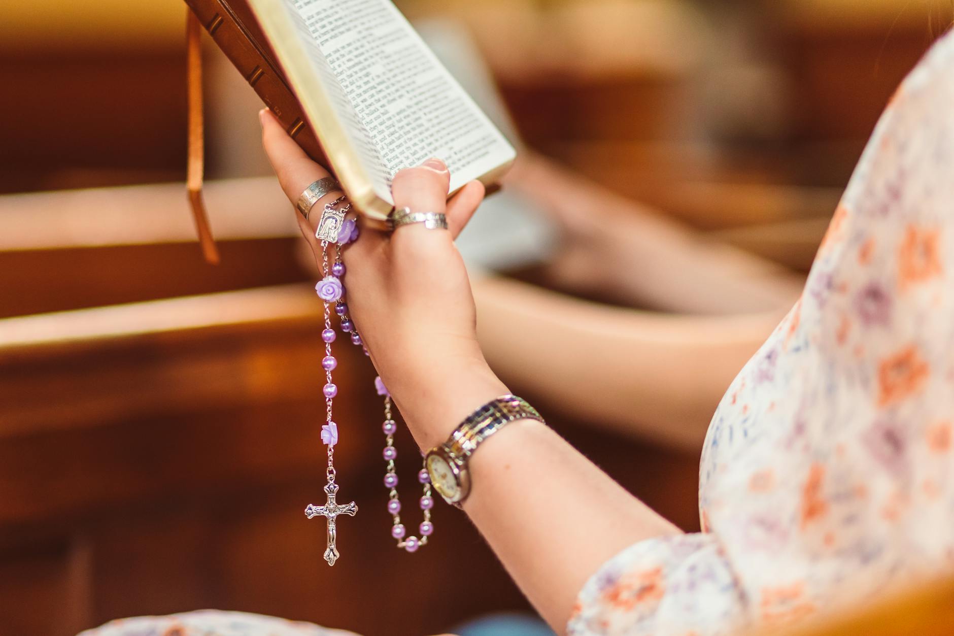crop photo of woman reading the bible and praying